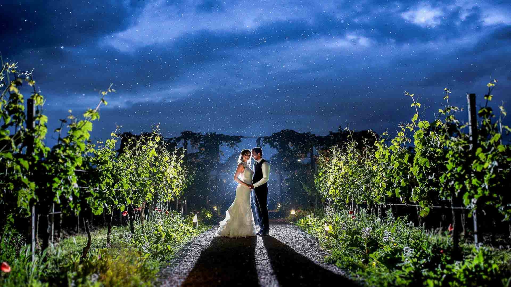 Hochzeitspaar zur blauen Stunde bei Regen in den Weinbergen