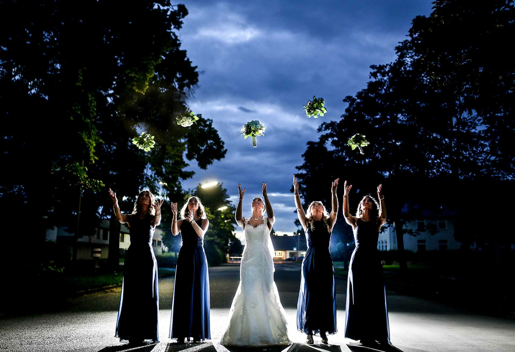 Braut und Ihre Freundinnen werfen den Brautstrauß zur blauen Stunde am Tag der Hochzeit in Wetzlar